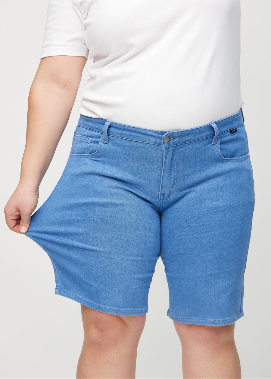 The plus-size model stretches the shorts at the thigh to show the stretch.