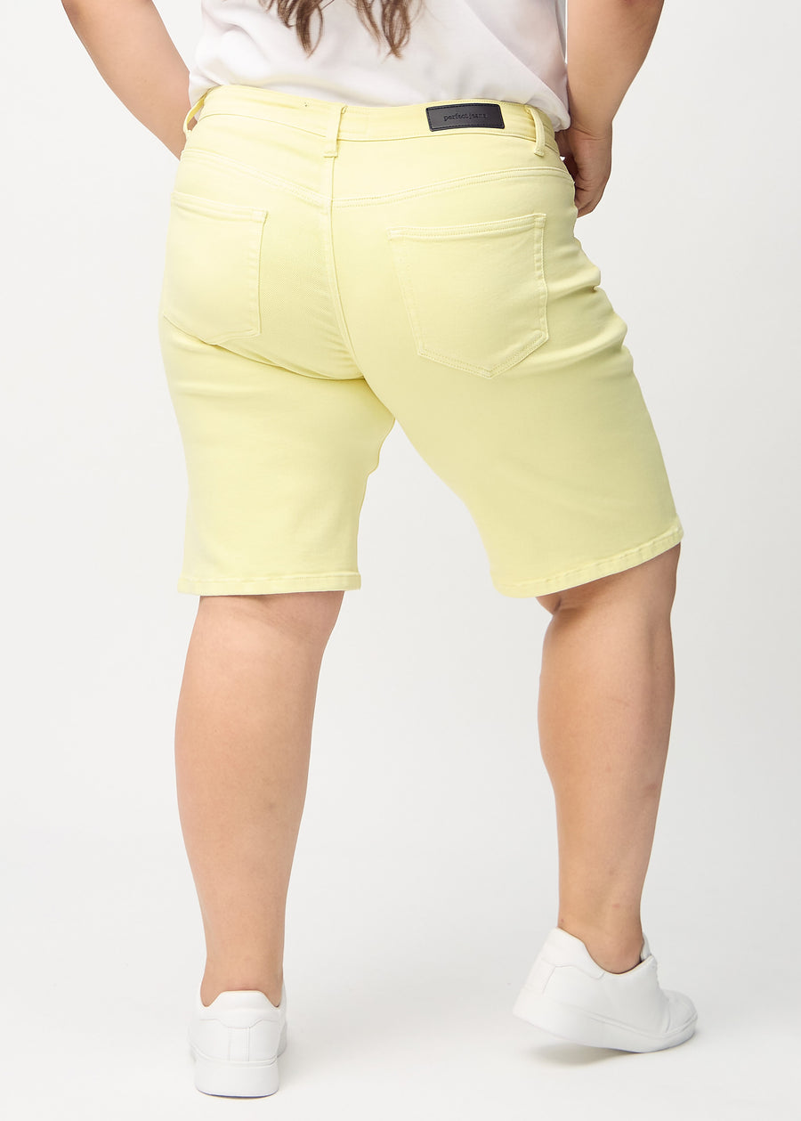 Light yellow regular middle shorts seen from the back on a plus-size model, so the entire product can be seen.