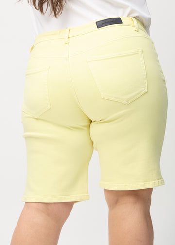 Light yellow regular middle shorts seen from the back close up on a plus-size model to show details.