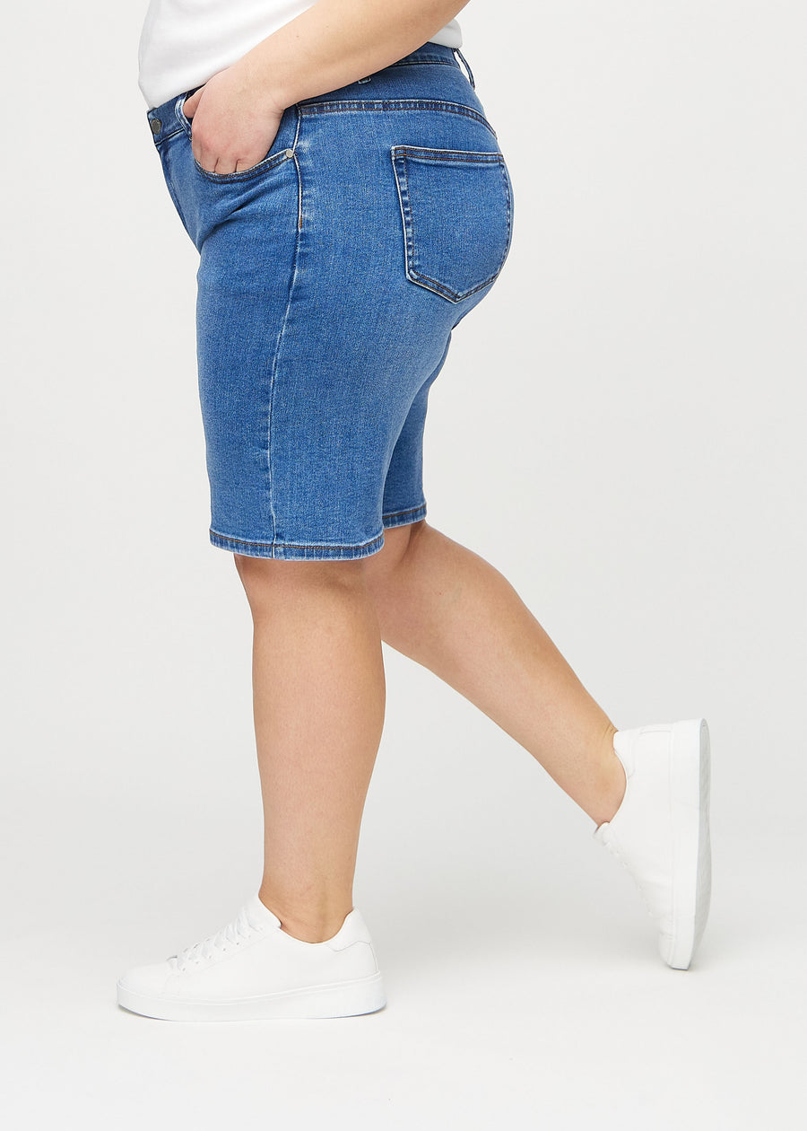 Denim regular middle shorts seen from the side on a plus-size model.