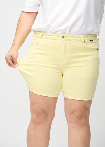 The plus-size model stretches the shorts at the thigh to show the stretch.