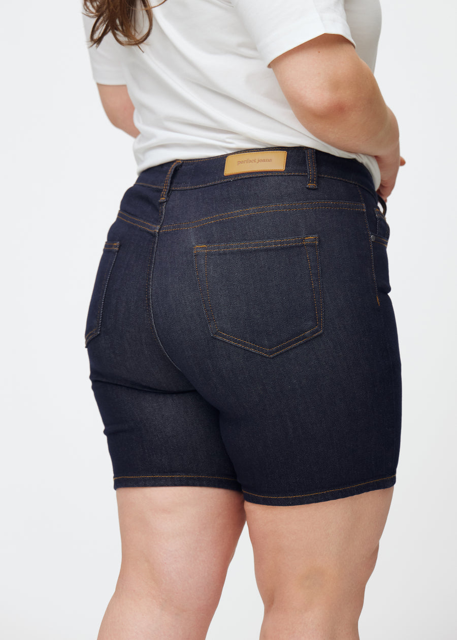 Deep dark blue denim shorts for women in the colour Midnights seen from the back in close-up on a plus-size model to show fit and details.
