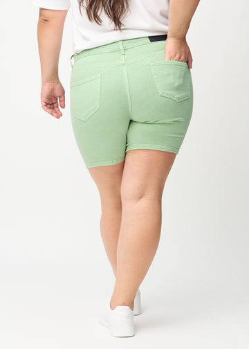 Light green skinny short shorts seen from the back on a plus-size model, so the entire product can be seen.