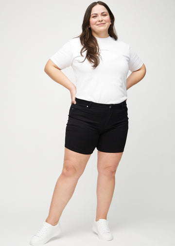 Full image of a plus-size model wearing black skinny short shorts.