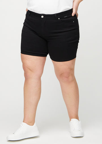 Black skinny short shorts, style name Ravens, which fit closely and end mid-thigh on a plus-size model, seen from the front.