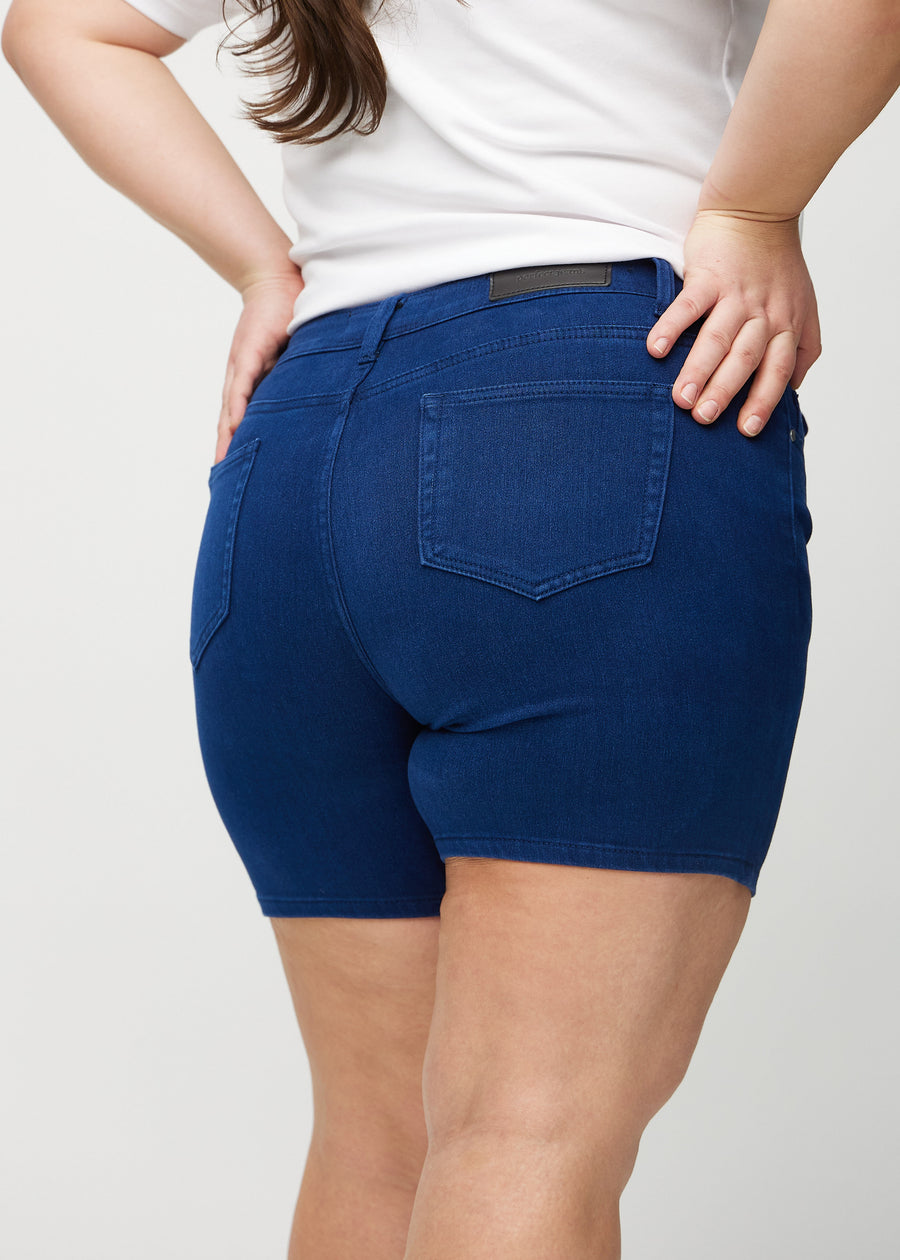 Dark blue skinny short shorts seen from the back close up on a plus-size model to show details.