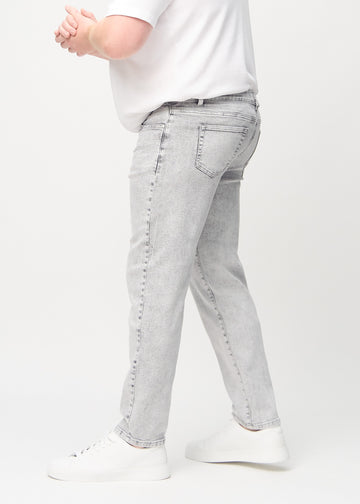 Light grey denim regular jeans seen from the side on a plus-size model.
