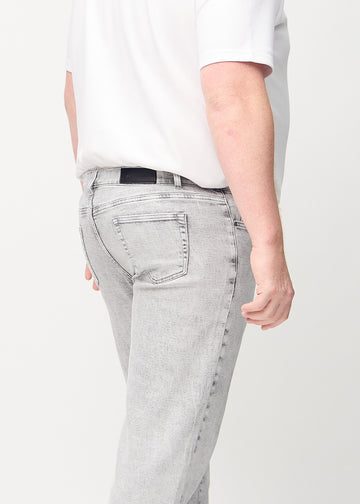 Light grey denim regular jeans seen from the back close up on a plus-size model to show details.
