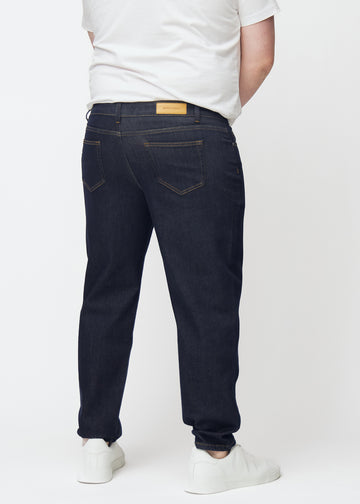 Deep dark blue denim jeans for men in the color Midnights seen from the back on a plus-size model.