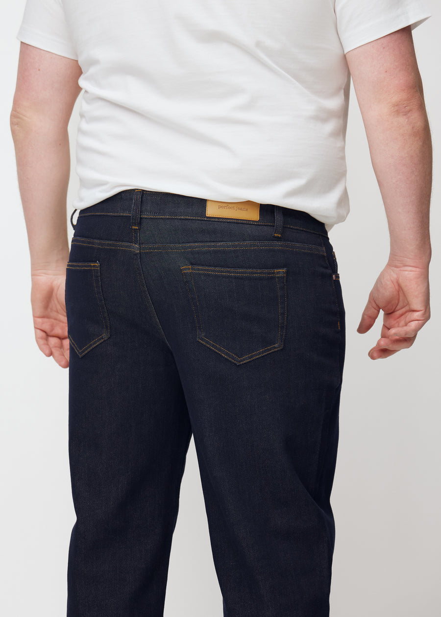 Deep dark blue denim jeans for men in the color Midnights seen from the back in close-up on a plus-size model.