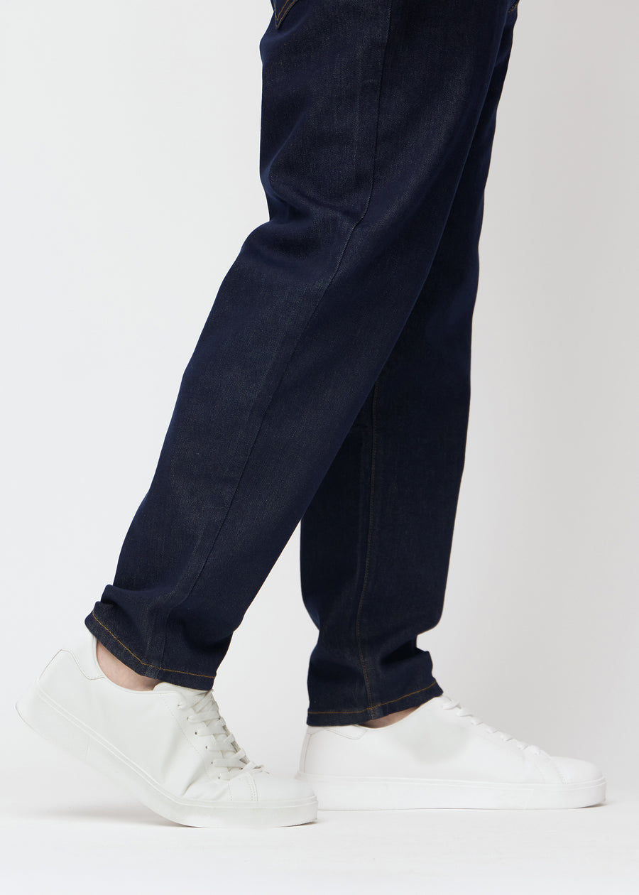 Deep dark blue denim jeans for men in the color Midnights with a regular fit seen close up at the ankles on a plus-size model to show the straight finish.