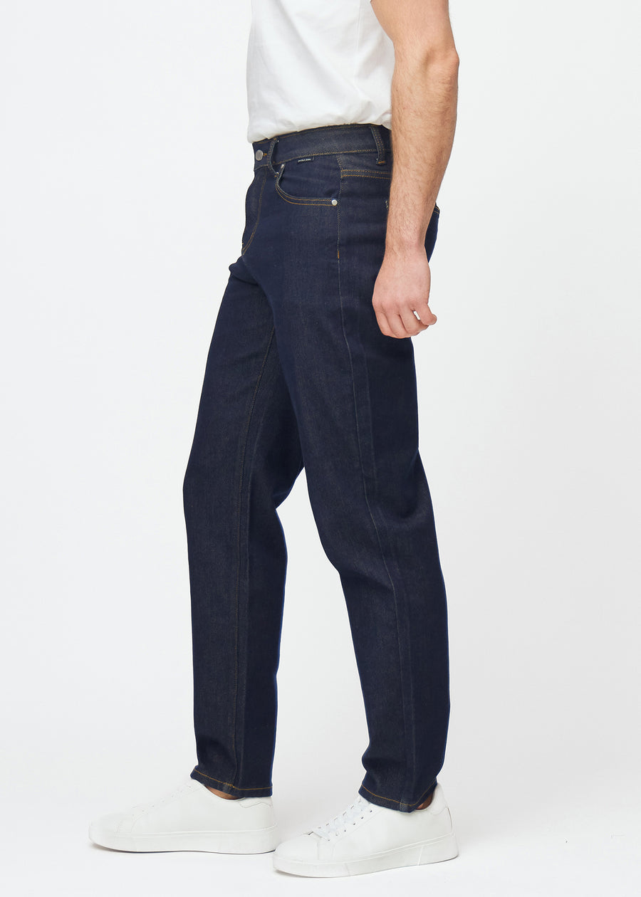 Deep dark blue denim jeans for men in the color Midnights with a regular fit seen from the side on a model.