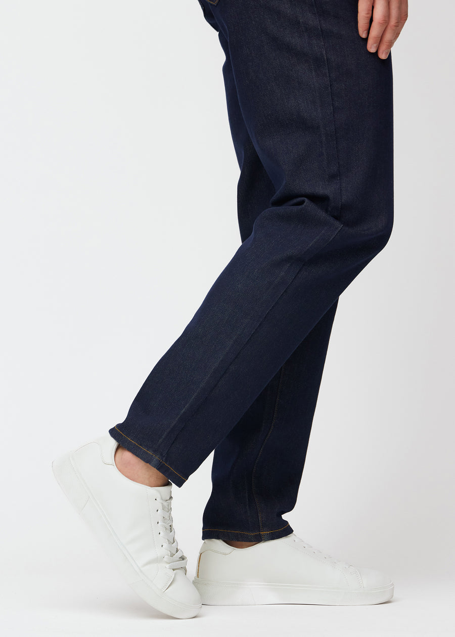 Deep dark blue denim jeans for men in the color Midnights with a regular fit seen close up at the ankles to show the straight finish.