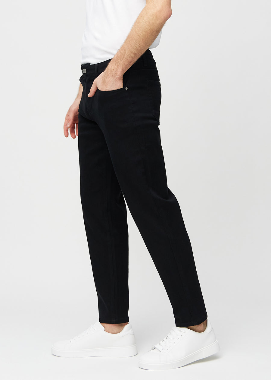 Black regular jeans seen from the side on a model.