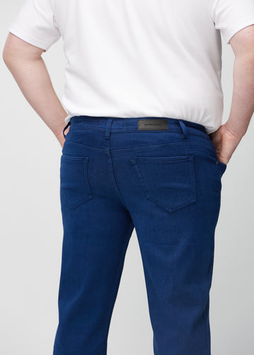 Dark blue regular jeans seen from the back close up on a plus-size model to show details.