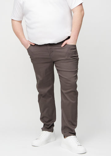 Grey-brown regular jeans, model name Thunders, which go straight down the leg on a plus-size model, seen from the front.