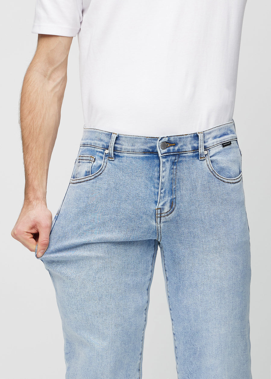 The model stretches the jeans at the thigh to show the stretch.