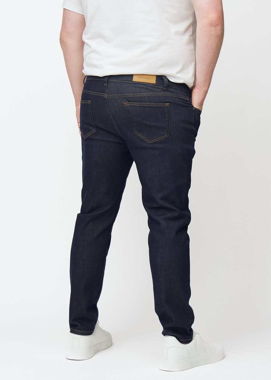 Deep dark blue denim jeans for men in the color Midnights seen from the back on a plus-size model.