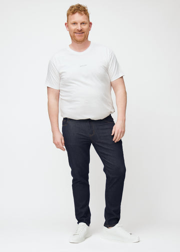 Full image of plus-size model in deep dark blue denim jeans for men in the color Midnights with a slim fit.