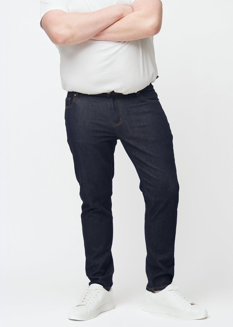 Deep dark blue denim jeans for men in the color Midnights with a slim fit seen from the front on a plus-size model.