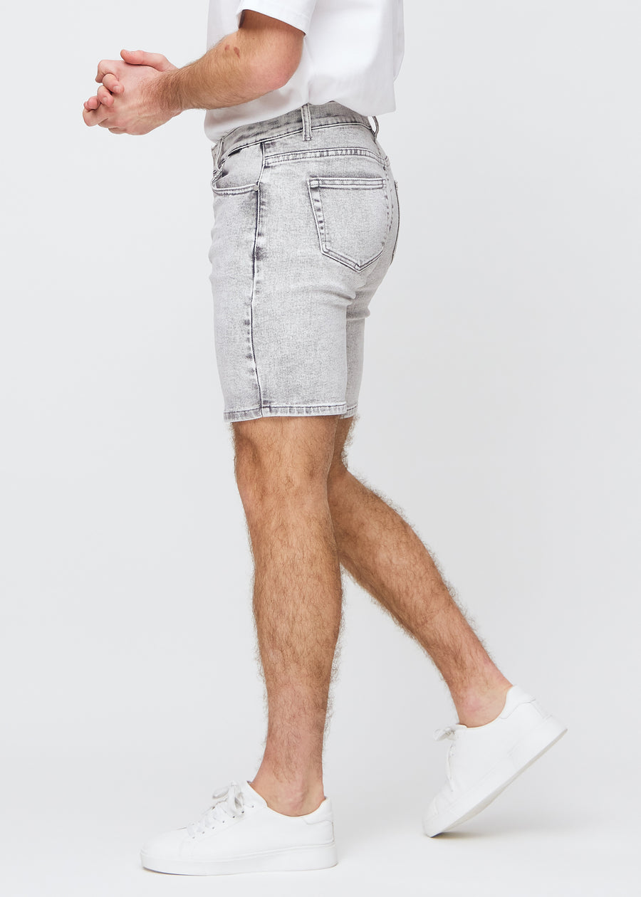 Light grey denim middlelslim shorts seen from the side on a model.