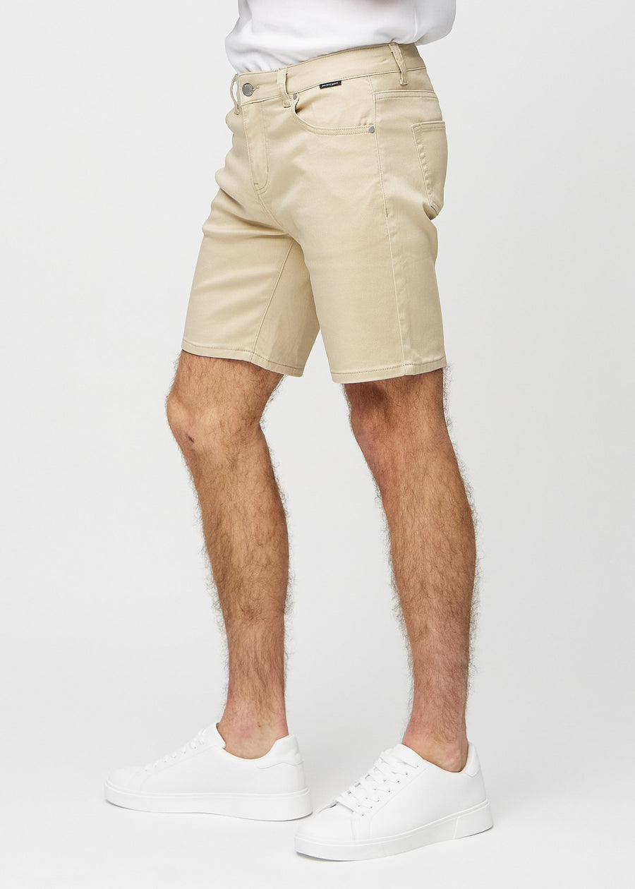 Beige middle-slim shorts seen from the side on a model.