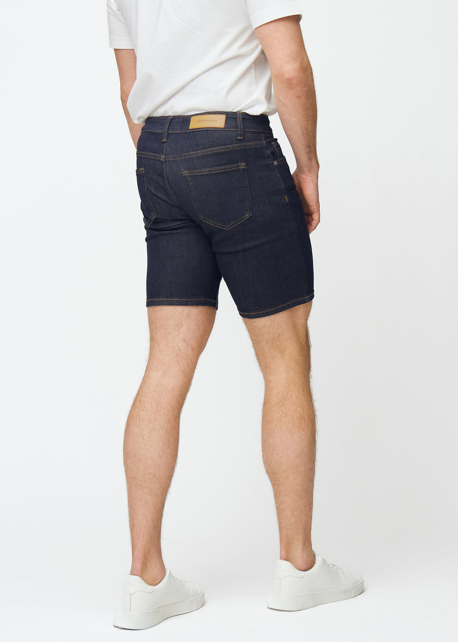 Deep dark blue denim shorts for men in the colour Midnights seen from the back, showing the length just above the knee.