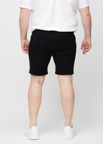 Black middle-slim shorts seen from the back on a plus-size model, so the entire product can be seen.