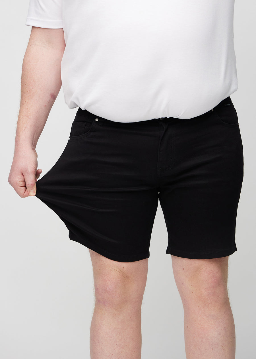 The plus-size model stretches the shorts at the thigh to show the stretch.