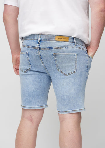 Light denim middle-slim shorts seen from the back in close-up on a plus-size model to show details.