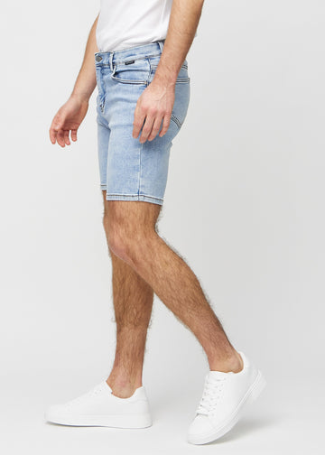 Light denim middle-slim shorts seen from the side on a model.
