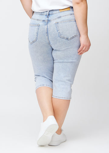 Lyseblå denim slim capris set bagfra på en plus-size model – tydeligt billede af hele produktet og lommer.
