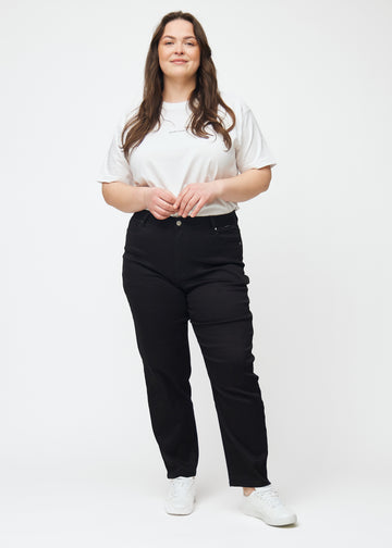 Plus-size model går ind i billedet, strækker i jeansene, viser dem frem ved at dreje rundt, og forlader derefter billedet.