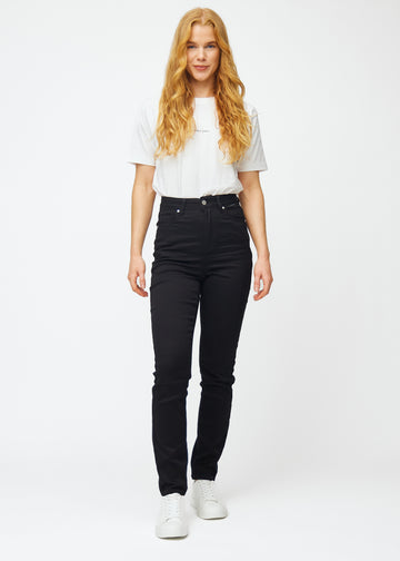 Model går ind i billedet, strækker i jeansene, viser dem frem ved at dreje rundt, og forlader derefter billedet.