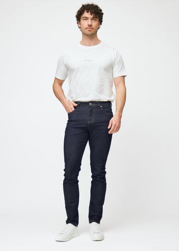 Model viser dyb mørkeblå denim jeans til mænd i farven Midnights med slim pasform i bevægelse.