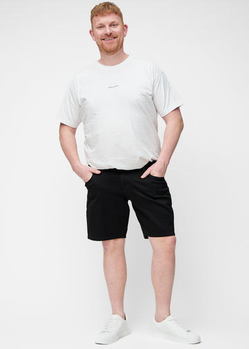 Plus-size model viser sorte shorts til mænd i farven Ravens med regular pasform i bevægelse.